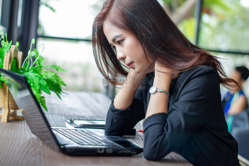 桌子白色的亚裔女商人认真对待所做工作直到头痛为止女孩图片