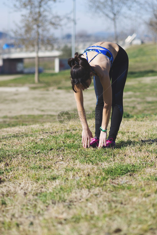 慢跑者身体在公园里做伸展运动的漂亮女人图片