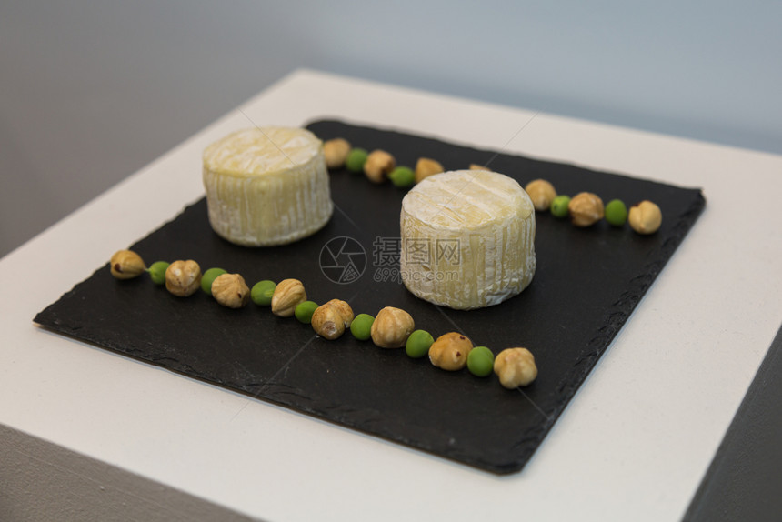 典型的产品黑桌布上两块托米诺奶酪与皮斯和奇克佩一起装饰于2线托米诺奶酪与皮斯和奇克一道装饰在1线的黑桌布上食物图片