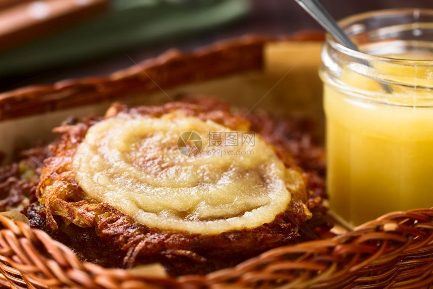 进入蛋糕磨碎的新鲜自制土豆薄煎饼或配菜篮子苹果酱的煎饼一种传统的德国小吃或餐盘叫做Kartoffelpuffer或Reibeku图片