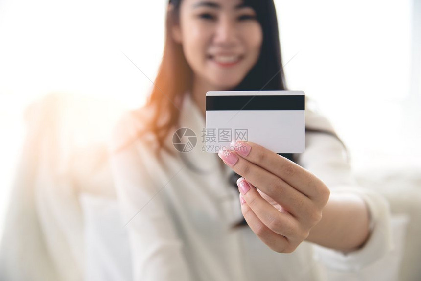 女士愉快经过网上购物及简单支付概念在网路购物与简便支付概念下亚洲美容女信用卡持有量接近关闭图片