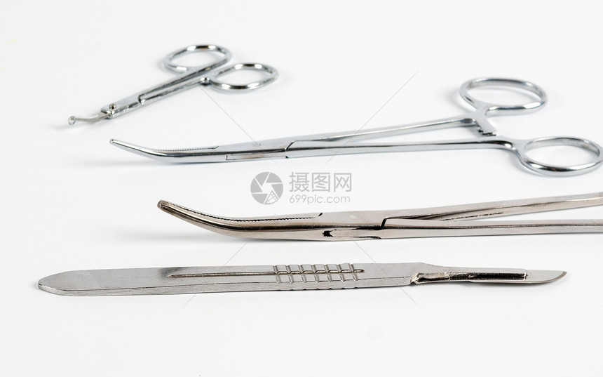 补给品医生白色背景的刀片和医疗夹具有选择焦点手术图片