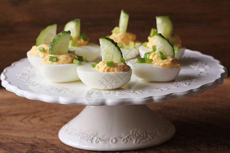 手指一顿饭鸡蛋用黄瓜和黑嘴水泡在白色盘子上鸡蛋用黄瓜和白盘子上美味的图片