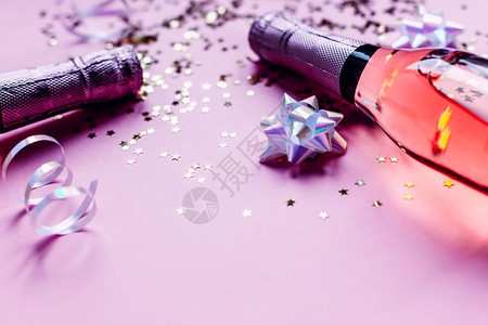 火花灯圣诞或新年配有玫瑰香槟和金光闪星彩色面粉红背景的彩蛋边观党庆祝创意概念的喜庆晚会问候背景图片
