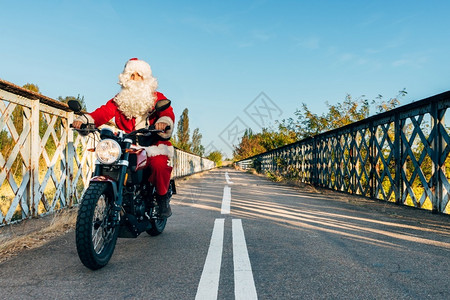 自行车骑的人庆典圣诞老在路上骑摩托车圣诞老人在路上骑摩托车图片