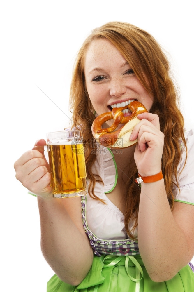 白色的身着巴伐利亚洋装的红发女人身着啤酒吃白底面蛋饼的啤酒身着巴伐利亚洋装的Britzel红发女人典型的可口图片