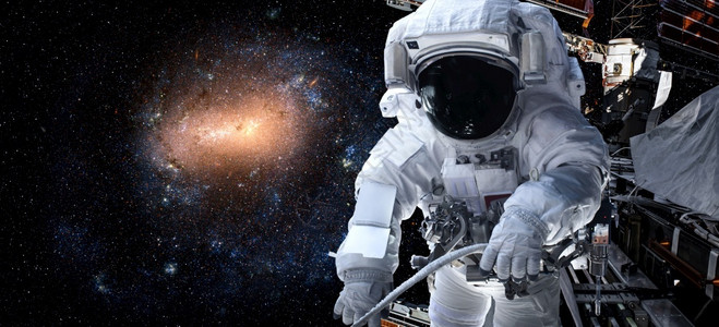 宇航员太空人在为外层间的站工作时进行太空走宇航员穿着全套太空服进行操作美航空天局科学行星背景图片