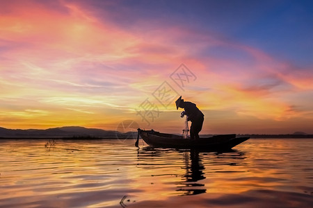日落缅甸工作在自然湖中日出时在自然湖中的木船上渔民轮椅树液高清图片素材