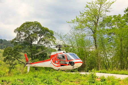 森林机器引擎小型私人直升机在草地上用小型私人直升机抵挡云中山顶图片