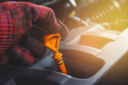 用橙色测量发动机系统油水平的械手持低压油层级计汽车维修概念用于检查发动机系统的油水平抓住关心力量仪表高清图片素材