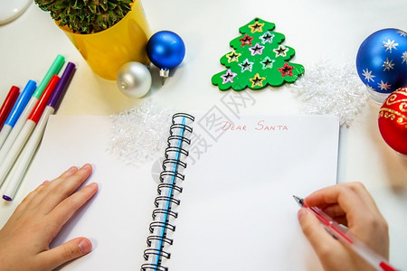 孩子在圣诞装饰的桌子上给圣诞老人写信图片
