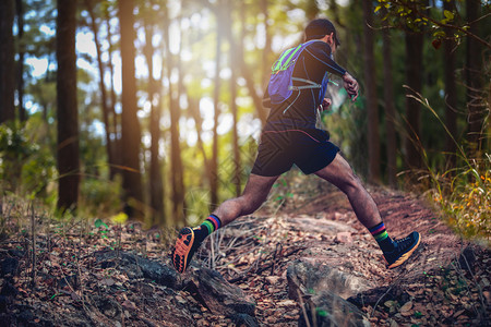 男人女孩极端骑着运动鞋在森林中跑步的脚下穿着运动鞋在森林中奔跑图片
