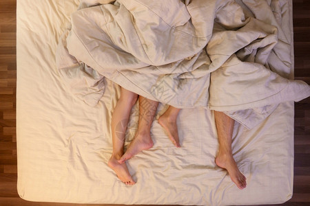 浪漫的脚丫子在卧室床单下的上男女双脚紧贴地亲近热情背景图片