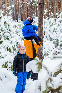 美丽的冬天父亲带着年幼的孩子在树林里散步雪地橇和球中的冬季活动女自然图片