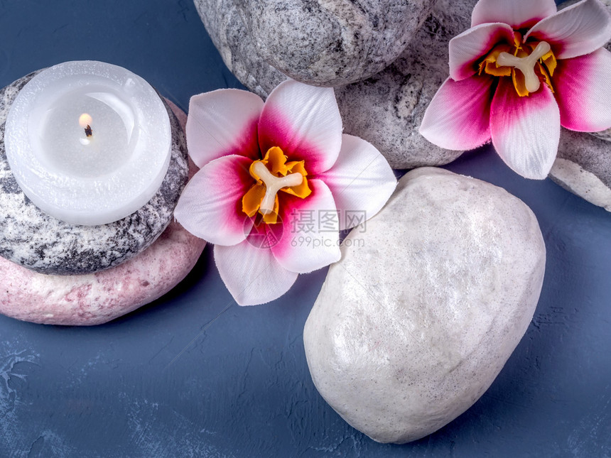 蜡烛鲜花和毛巾斯帕布构成的由石头鲜花和燃烧的蜡烛组成结石和平草本图片