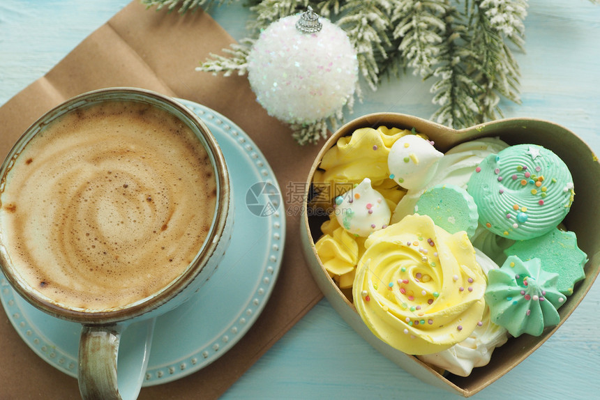 爱圣诞节一杯含泡沫的咖啡一个含有不同颜色的蛋白质心形盒子一个圣诞舞会和fir树枝蛋白甜饼图片