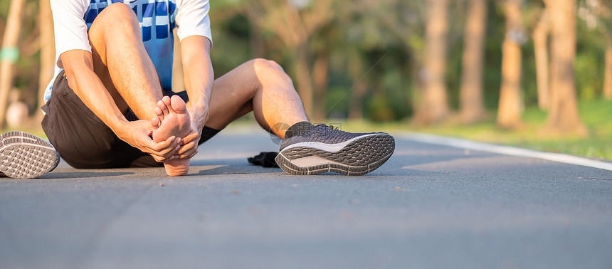 自然事故娱乐在训练亚裔运动员在上午和健康概念外跑步和锻炼后脚有单手疼痛和问题身着运动腿部受伤肌肉疼痛的年轻健身壮男子在训练亚裔跑图片