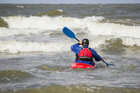 骑着皮艇在海浪波的水上划艇娱乐皮竞赛图片