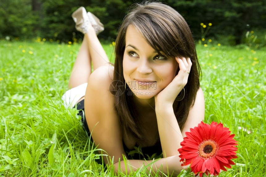 快乐的女士躺在草地上花松弛肖像图片