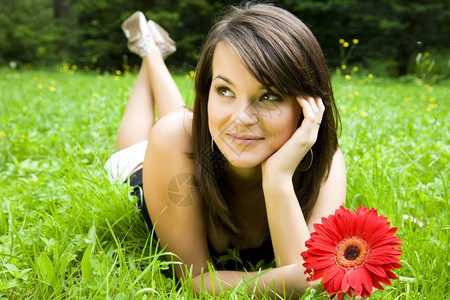 快乐的女士躺在草地上花松弛肖像美丽高清图片素材