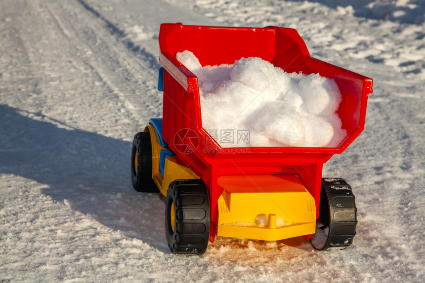 中断运输城市玩具卡车在冬季清除路上的雪图片