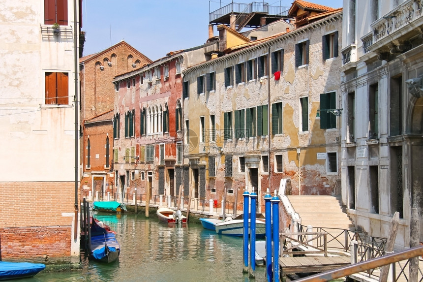 晴天水码头在意大利威尼斯的一条运河上房屋和船只图片