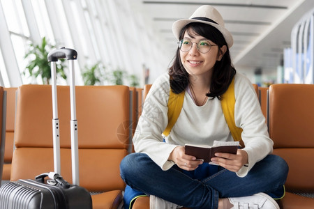 坐着新鲜欢乐的亚洲女旅行者正在机场等待航班假日旅行期等手提箱乘客高清图片素材