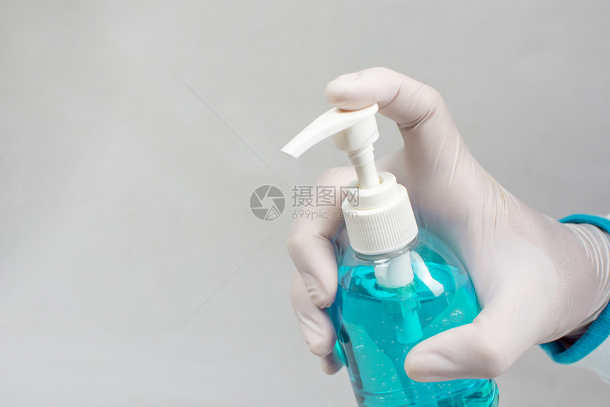 Covid19预防Alcohol防毒剂瓶装在医生的手中用于防止带有复制空间的感染Corona医院蓝色的爆发图片