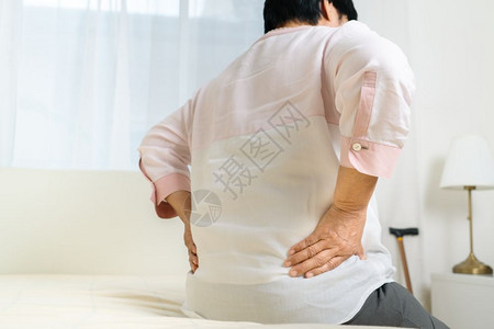 成熟腰痛屋老年妇女在家里背痛老年概念的保健问题老年人的后背痛苦图片