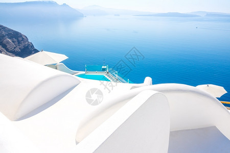 希腊桑托里尼岛传统白色屋顶和蓝游泳池边缘图片
