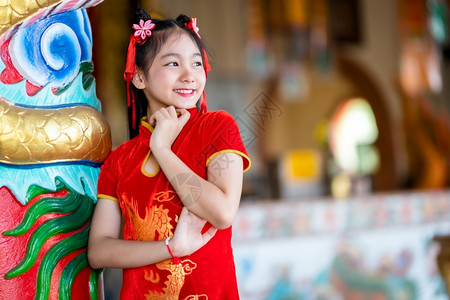国之图腾身着中华新年节国青春红传统香藏装饰的可爱亚洲小女孩长得一脸美丽的笑并戴着彩礼宗教淑女可爱的背景