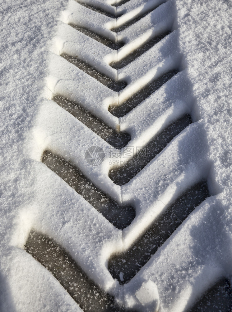 黑色的踪迹冷冻下雪后新中拖拉机的痕迹胎面技术的结构和痕迹细节拖拉机特写痕迹图片