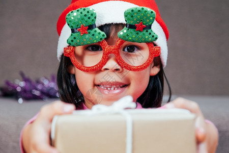 肖像帽子快乐的小女孩戴着圣诞帽在家送礼物新年快乐圣诞展示图片