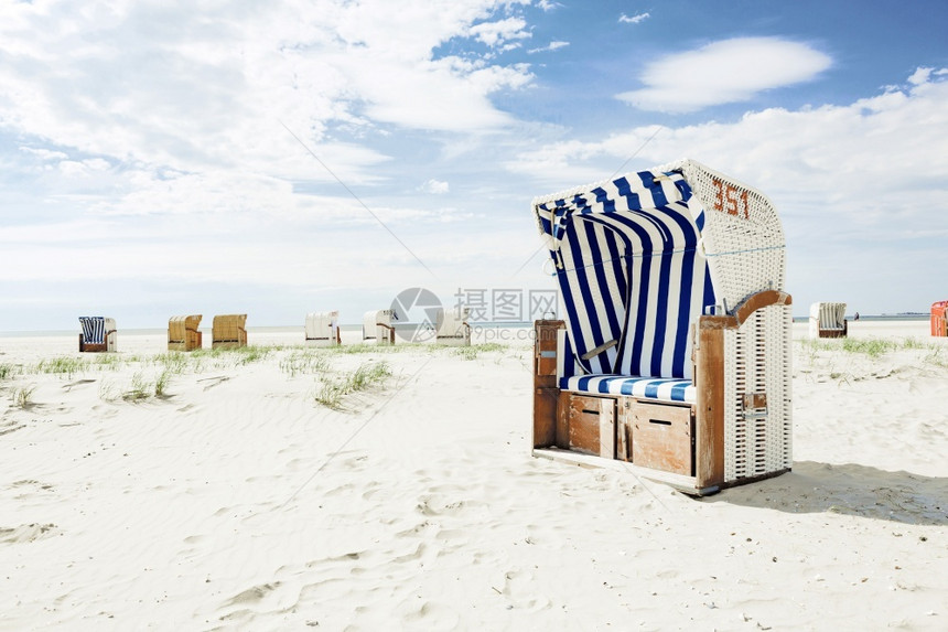 度假村蓝色和白条纹木制圆板椅子或长在夏季炎热阳光下的一个白色沙热带海滩上旅行和度假概念木制的云图片