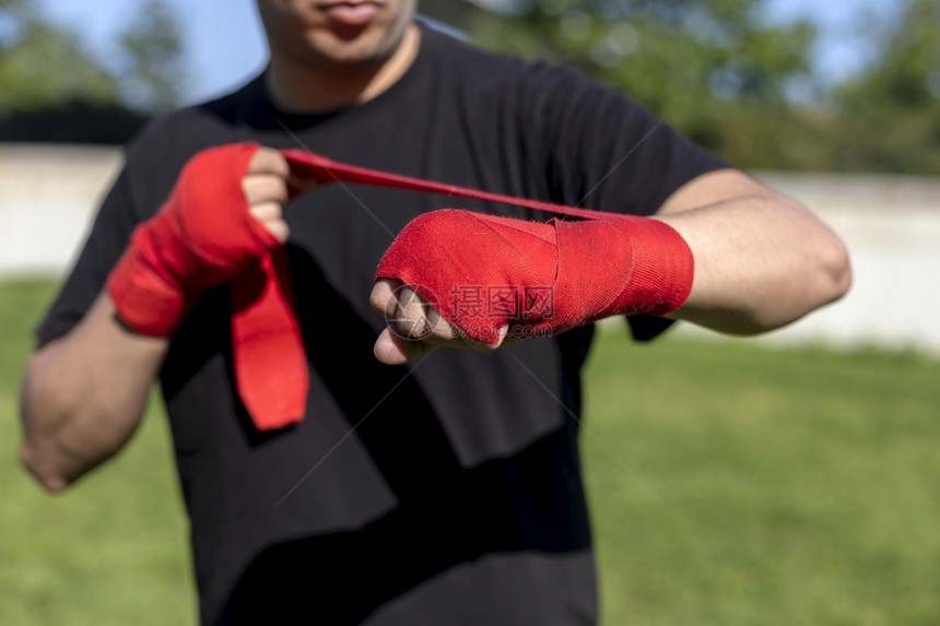 准备在户外用前臂绷带训练的拳手为了保护出汗图片