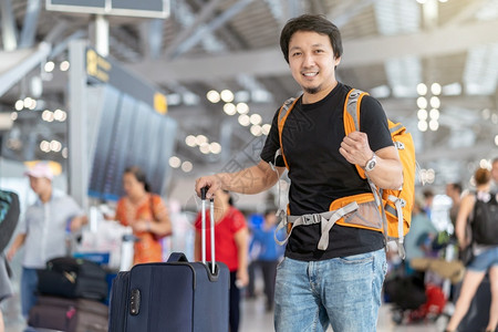 飞机在现代场行信息屏幕上登机旅行和具有技术概念的运输等现代机场旅行和运输时有护照的亚洲旅行者在飞板上站立着检查行李的肖像终端快乐车站高清图片素材