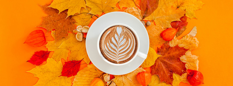 多色秋叶上的咖啡拿铁背景图片