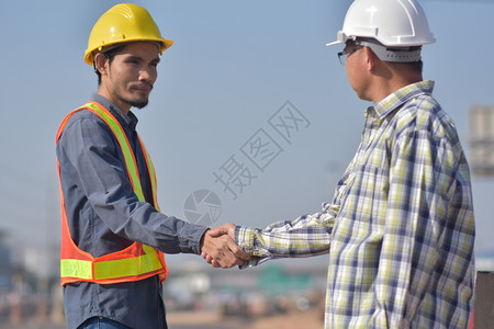 男人地点建筑师施工地程与匠握手图片