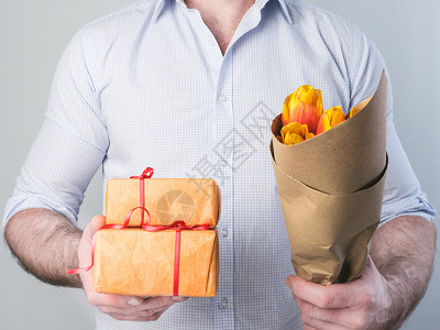 人有礼物和鲜花送给他所爱的一个人有礼物和鲜花人们女丈夫周年纪念日高清图片素材