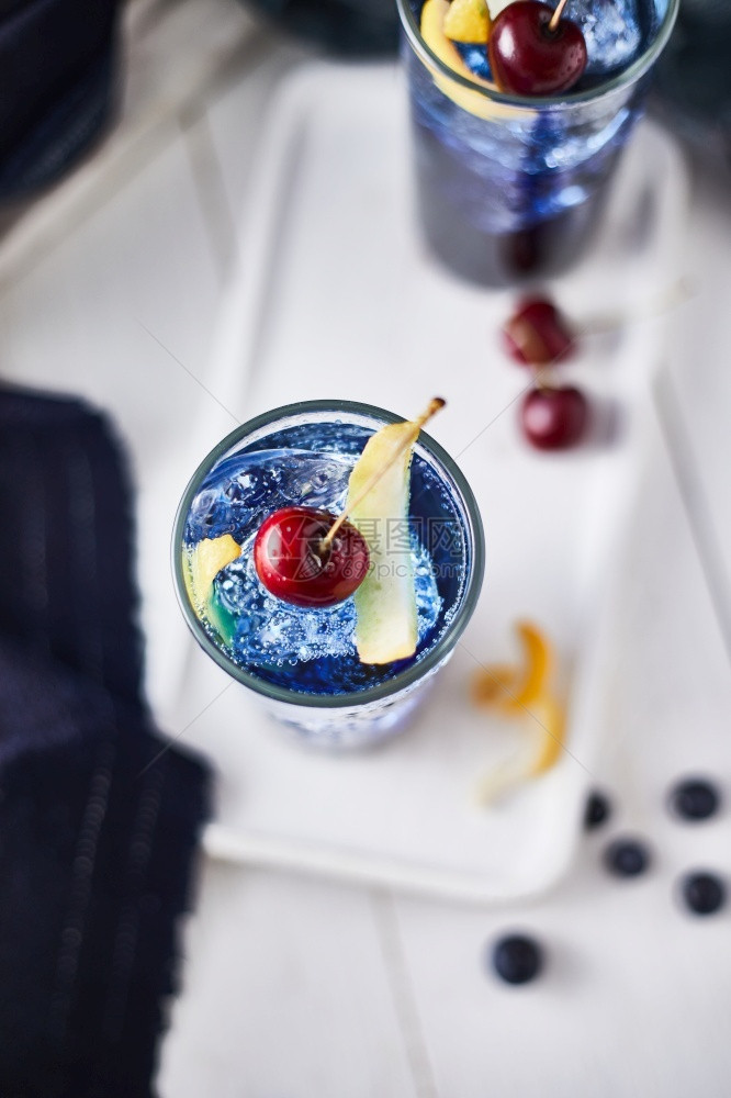 新鲜蓝莓鸡尾酒加柠檬皮和樱桃丰富多彩的自制液体图片