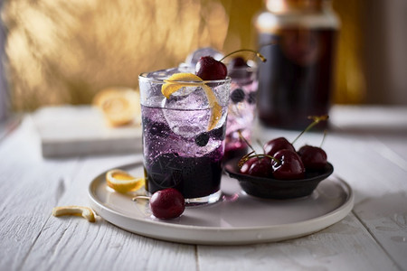 新鲜蓝莓鸡尾酒加柠檬皮和樱桃新鲜的红色莫吉托背景图片