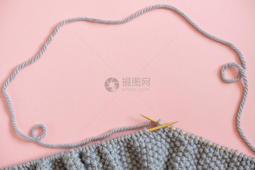 为了毛衣针上的一块灰色织物粉红背景上的针织过程复制文本的空间顶视图平躺模板适合您的设计针上灰色织物粉红背景的针织过程复制文本空间图片