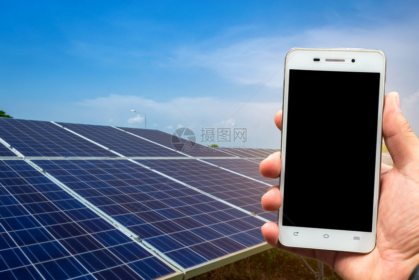 充电器男子在太阳能电池板背景下使用智能手机模糊图像如可再生能源和清洁一亚洲人电工图片