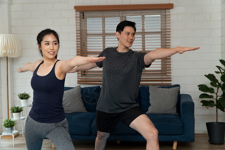居家瑜伽锻炼的夫妇图片