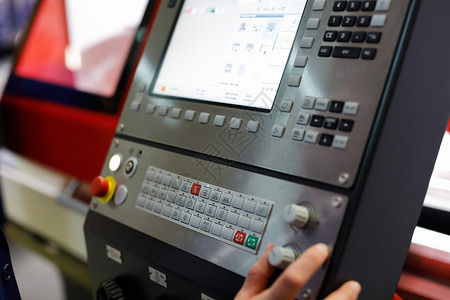 机械作坊车床工人使用控制面板和显示焦点控制CNC机器的操作选择焦点图片