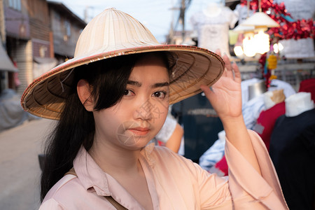 优质的看身戴越南草帽面带笑脸背景模糊的亚洲女肖像年轻美女孩图片