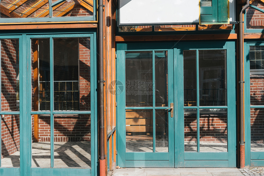 玻璃窗和有绿宝石框架的门在红砖欧洲面罩上白色的建造筑学图片