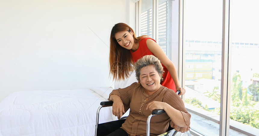 家自然高级的坐在轮椅上照顾外婆的开心女人图片