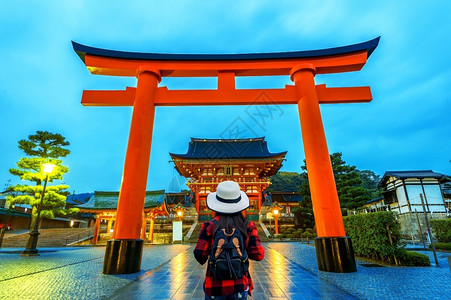 撑船赏荷女孩在日本京都fushimiInaritaisha神庙带背包的女旅行者托里古老的地标背景