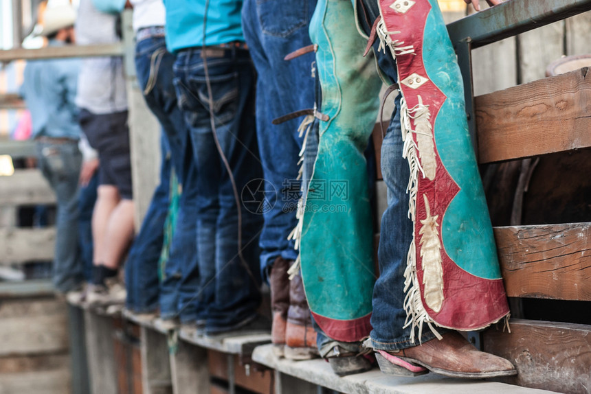 与蓝皮靴和分会一起站在旧木质铁路上的罗多牛仔队列年轻的鞋美丽图片